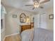 Bedroom with a wood dresser, mirror, ceiling fan, closet, and a view into the hallway, all with natural light at 1600 S Wade Ave, Garner, NC 27529