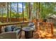 Outdoor deck with a seating area, including chairs and a table, surrounded by a wooded area at 1600 S Wade Ave, Garner, NC 27529