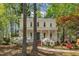 Inviting yellow home with a welcoming front porch surrounded by beautiful trees and greenery at 1600 S Wade Ave, Garner, NC 27529