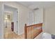 Bright upstairs hallway with wood railing, open doorway, and access to multiple rooms at 1600 S Wade Ave, Garner, NC 27529