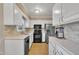 Well-lit kitchen with white cabinetry, modern appliances, and ample counter space for meal prep at 1600 S Wade Ave, Garner, NC 27529
