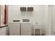 Well-equipped laundry room with modern washer, dryer, sink, and overhead storage at 1653 Goldfinch Perch Ln, Knightdale, NC 27545