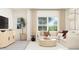 Bright living room features large windows, neutral tones, and comfortable sectional seating arrangement at 1653 Goldfinch Perch Ln, Knightdale, NC 27545
