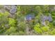 An aerial view of a home surrounded by green trees, featuring a dark roof, driveway, and mature landscaping at 1705 Lord Ashley Dr, Sanford, NC 27330