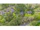 An aerial view of a home nestled among lush greenery, featuring a dark roof, driveway, and natural landscaping at 1705 Lord Ashley Dr, Sanford, NC 27330