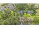 An aerial view of a home surrounded by lush green trees, featuring a dark roof and driveway at 1705 Lord Ashley Dr, Sanford, NC 27330