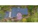 An aerial view of a home with a dark roof, driveway, and landscaping, with a pink flowering tree in the yard at 1705 Lord Ashley Dr, Sanford, NC 27330