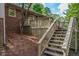 Backyard view with wooden deck and stairs leading down to the yard, against a brick home exterior at 1705 Lord Ashley Dr, Sanford, NC 27330