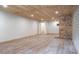 View of the finished basement with wood plank ceiling, a brick fireplace, and recessed lighting at 1705 Lord Ashley Dr, Sanford, NC 27330