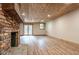 Basement with brick fireplace, wood ceiling, wooden floors and white-painted walls at 1705 Lord Ashley Dr, Sanford, NC 27330
