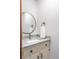 Well-lit bathroom features a granite vanity top, a round mirror, and stylish fixtures at 1705 Lord Ashley Dr, Sanford, NC 27330