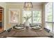 Well-lit dining area with an elegant wooden table and multiple windows providing natural light at 1705 Lord Ashley Dr, Sanford, NC 27330