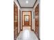 Inviting hallway features multiple wood doors and light ceramic tile flooring at 1705 Lord Ashley Dr, Sanford, NC 27330