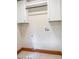 Functional laundry room with wooden trim and white cabinets for storage at 1705 Lord Ashley Dr, Sanford, NC 27330
