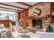Cozy living room featuring a brick fireplace, wood beams, and built-in bookshelves at 1705 Lord Ashley Dr, Sanford, NC 27330