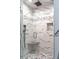 Close up of walk-in shower with pebble floor, marble-look tile, and shower bench at 1705 Lord Ashley Dr, Sanford, NC 27330