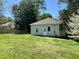 The backyard is spacious with lots of green grass and tree coverage, offering a private outdoor setting at 1716 Turner St, Roxboro, NC 27573