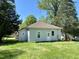 The backyard is spacious with lots of green grass and tree coverage, offering a private outdoor setting at 1716 Turner St, Roxboro, NC 27573