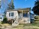 Charming home featuring a covered porch, black shutters, and a staircase leading to the entrance at 1716 Turner St, Roxboro, NC 27573