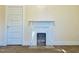 Living room featuring fireplace with white trim, door and tan carpet at 1716 Turner St, Roxboro, NC 27573