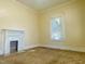 Living room featuring a fireplace with white trim, carpet flooring and lots of natural light from large windows at 1716 Turner St, Roxboro, NC 27573