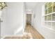 Bright hallway with light wood floors, white walls, and natural light streaming through the window at 1817 Heisser Ln, Fuquay Varina, NC 27526