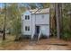 Charming two-story home featuring a blue front door, unique windows, and a metal roof surrounded by a wooded area at 19 Lansgate Ct, Durham, NC 27713