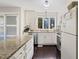 Well-lit kitchen featuring white cabinets, granite countertops, modern appliances, and dark hardwood flooring at 19 Lansgate Ct, Durham, NC 27713