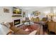 Cozy living room featuring a fireplace, mounted TV, stylish furniture, and a patterned rug on dark wood floors at 19 Lansgate Ct, Durham, NC 27713