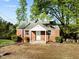 Charming brick home featuring a cozy front porch and mature trees at 203 W Pilot St, Durham, NC 27707