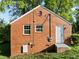 Back exterior of a brick home with two windows and a white door at 203 W Pilot St, Durham, NC 27707