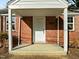 Close-up of the home's inviting covered front porch with brick facade at 203 W Pilot St, Durham, NC 27707