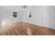 Spacious living room featuring laminate flooring, white walls, and natural light from two windows at 203 W Pilot St, Durham, NC 27707