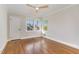 Empty bedroom with hardwood floors, three windows, and a modern ceiling fan at 206 Bickett Blvd, Raleigh, NC 27608
