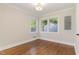 Bright bedroom featuring hardwood floors, white trim, and natural light from a set of windows at 206 Bickett Blvd, Raleigh, NC 27608