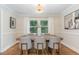 Dining room features an updated chandelier, large window, hardwood floors, and stylish wainscotting at 206 Bickett Blvd, Raleigh, NC 27608