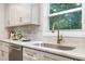 Granite counters and a stainless steel sink with gooseneck faucet are set under a window in this bright kitchen at 206 Bickett Blvd, Raleigh, NC 27608
