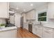 Bright kitchen features stainless steel appliances, custom cabinetry, granite countertops, and hardwood floors at 206 Bickett Blvd, Raleigh, NC 27608