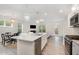 Bright, open kitchen with large island, stainless steel appliances, and modern lighting flowing into the living space at 210 Silas St, Durham, NC 27705