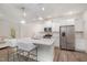 A modern kitchen featuring white cabinetry, a large island with quartz countertops, and stainless steel appliances at 210 Silas St, Durham, NC 27705