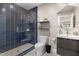 Modern bathroom with blue tiled shower, floating shelves, grey vanity, patterned tile floor and unique mirror at 211 Hargrove St St, Durham, NC 27701