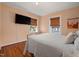 Cozy bedroom featuring wood floors, a large bed, and two windows with wood blinds at 211 Hargrove St St, Durham, NC 27701