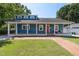 Charming blue home featuring a welcoming front porch, brick walkway, and lush lawn at 211 Hargrove St St, Durham, NC 27701