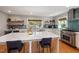 Open kitchen with a center island, stainless steel appliances, and custom blue backsplash at 211 Hargrove St St, Durham, NC 27701