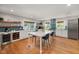 Bright kitchen featuring a large island, stainless steel appliances, and stylish blue backsplash at 211 Hargrove St St, Durham, NC 27701