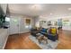 Living room flowing into the open kitchen, featuring hardwood floors and a gray sectional at 211 Hargrove St St, Durham, NC 27701