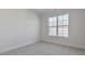 A bedroom is freshly painted with neutral carpet and a large window at 2322 Sugar Cone Way, Fuquay Varina, NC 27526
