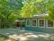 Wood back deck and blue siding offers an outdoor living space surrounded by mature trees at 2417 Lawrence Dr, Raleigh, NC 27603
