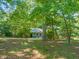 Home's back exterior features a wood deck and large windows, surrounded by mature trees at 2417 Lawrence Dr, Raleigh, NC 27603