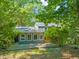 A backyard with a deck and a house with gray siding surrounded by lush greenery at 2417 Lawrence Dr, Raleigh, NC 27603